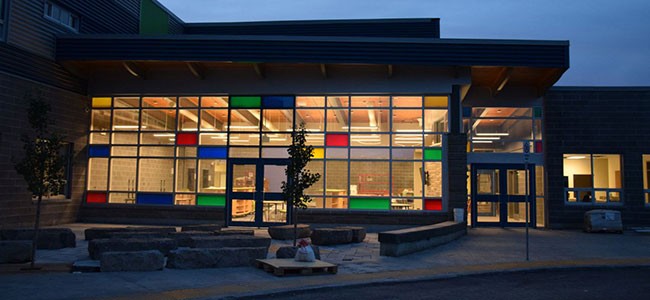 evening picture of front of school with coloured glass of library